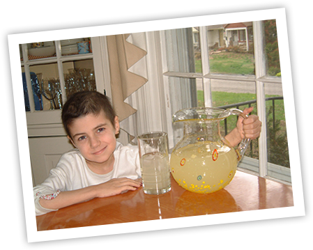 Alexandra Scott at a kitchen table with pitcher of lemonade 