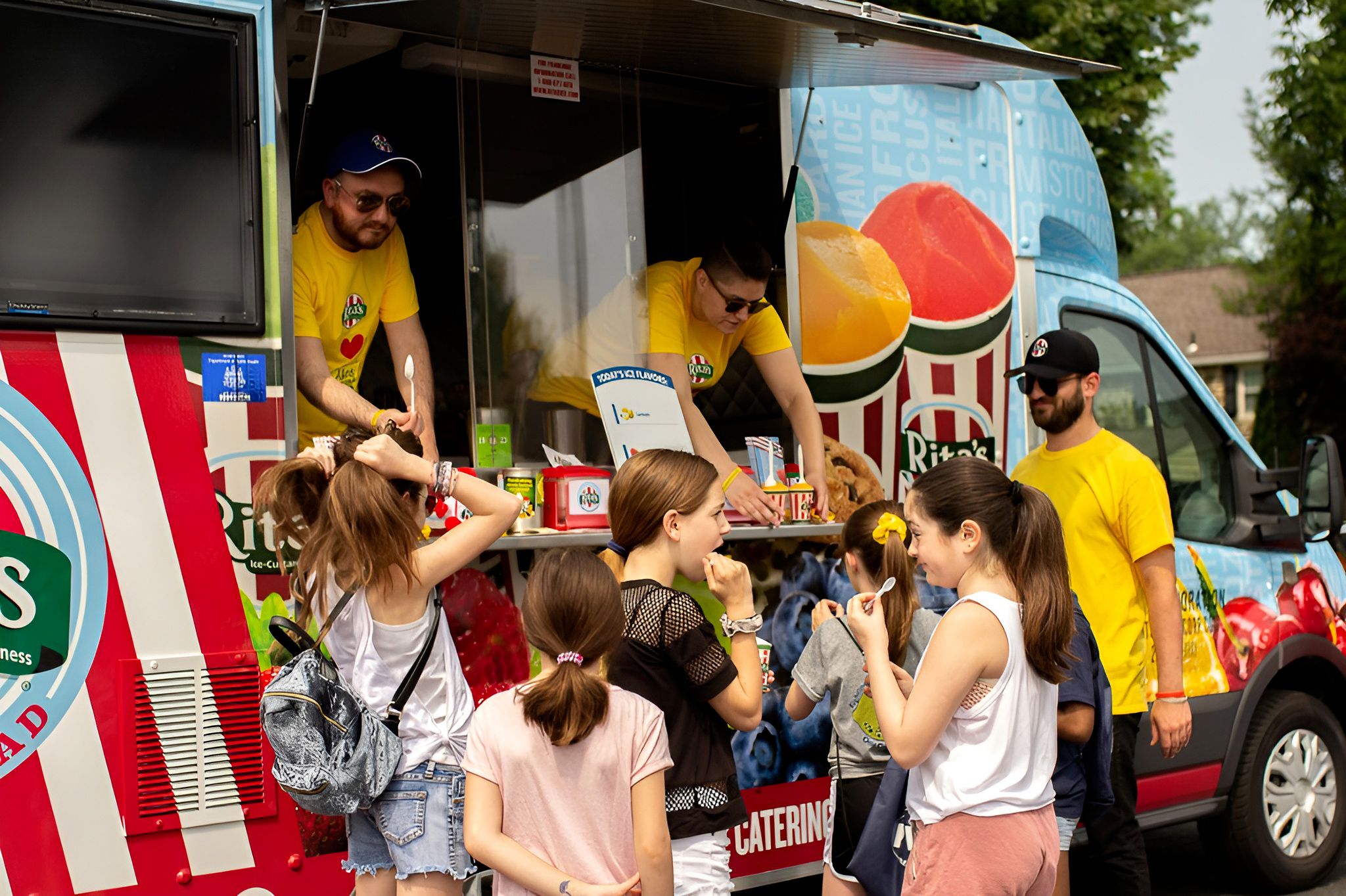 Rita's Water Ice employees hand out treats to kids from their truck
