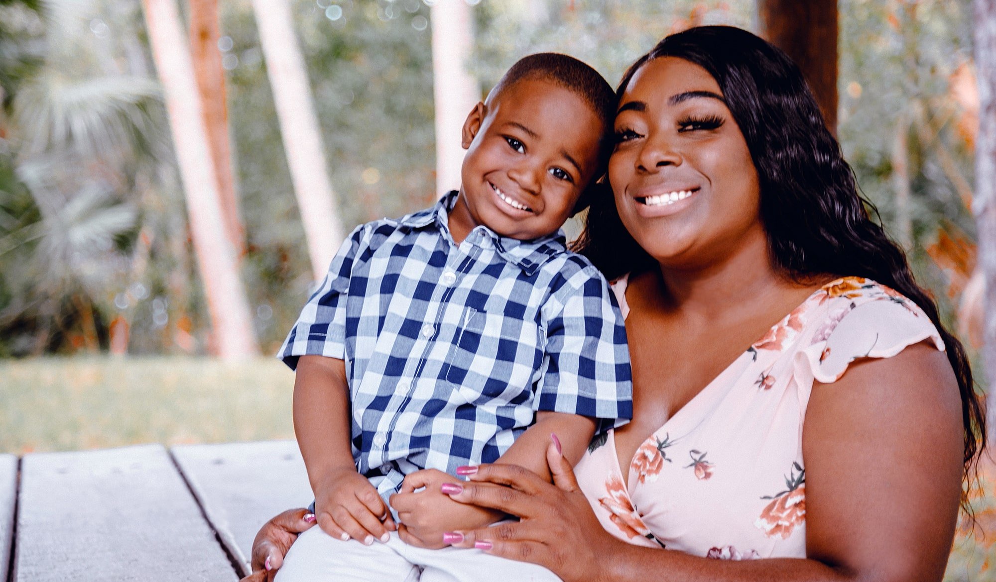 Mother holding son in her lap, both smiling